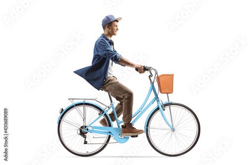 Full length profile shot of a casual guy riding a city bicycle