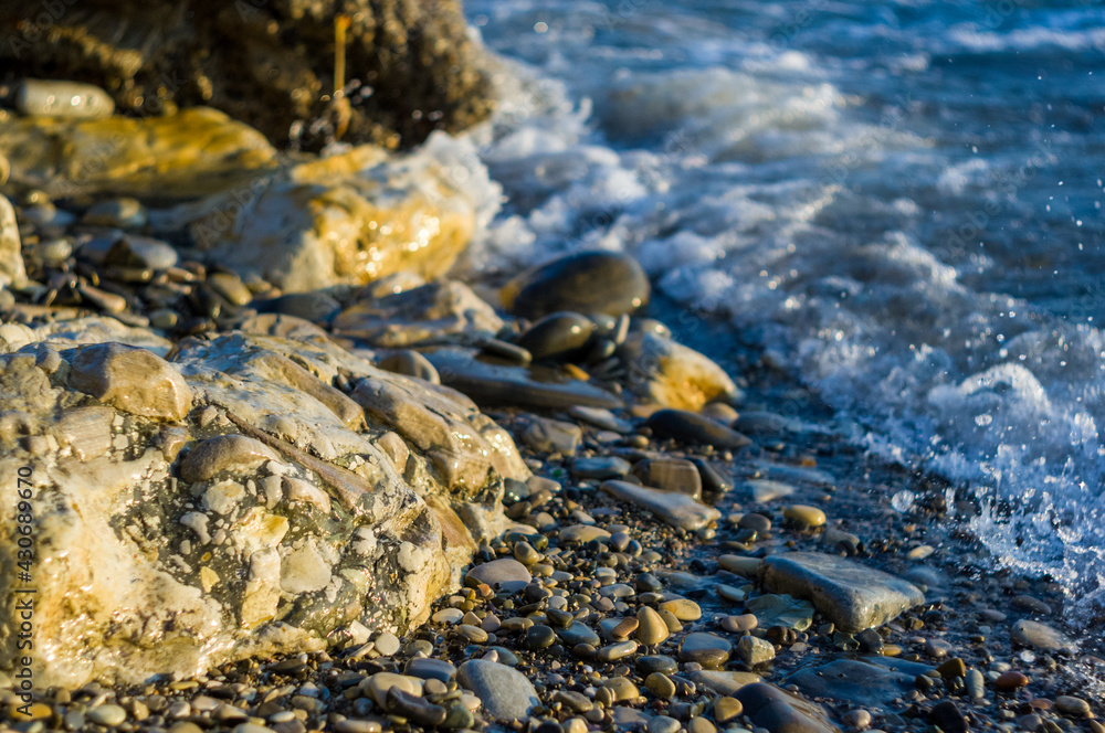 pebble stones on the sea beach, the rolling waves of the sea with foam pebble stones on the sea beach, the rolling waves of the sea with foam