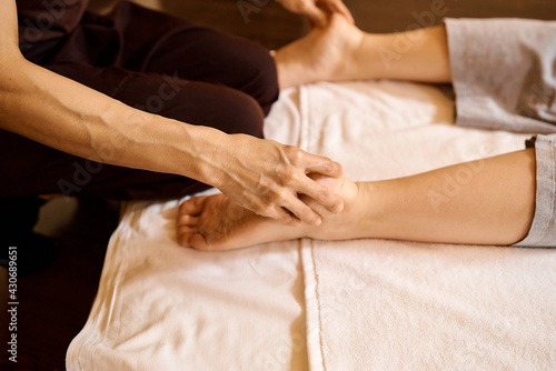 woman's hands do foot massage in beauty salon office