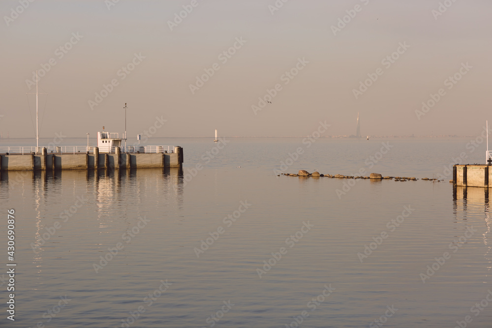 Marine pier for boats and yachts against the backdrop of the sunset. The Gulf of Finland.