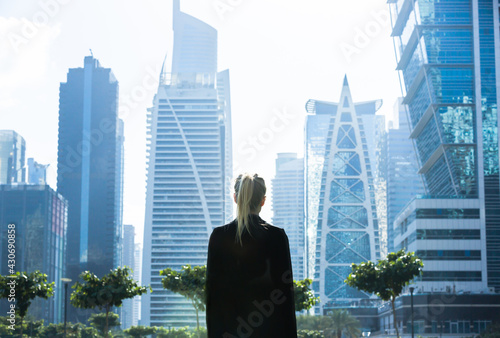 Business woman standing alone looking at the city skyline view. 