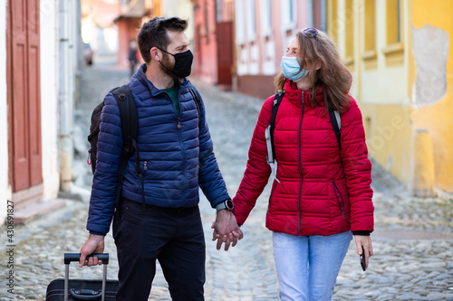 couple wearing mask on a city break covid travel passport