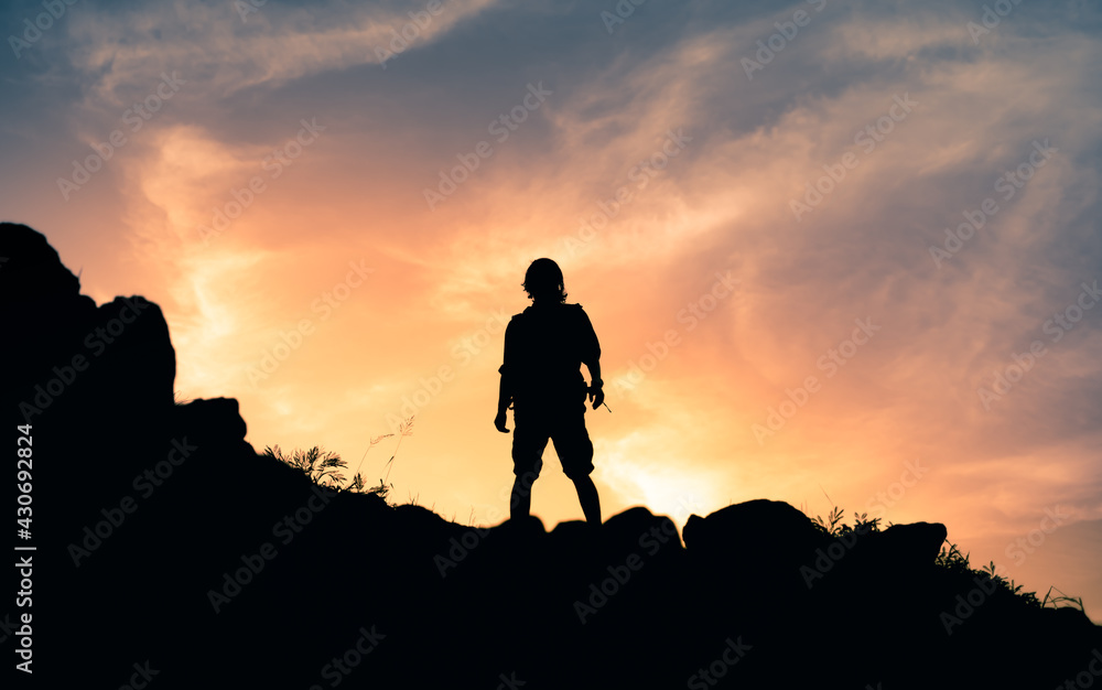 Strong confident man standing on edge of mountain top. Courage and strength concept.  