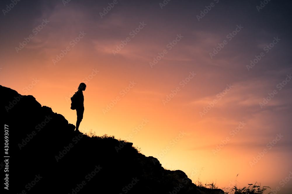 Man hiker standing on a mountain edge looking at the view. 