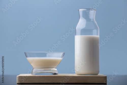 cup of milk with bottle on wood, blue background