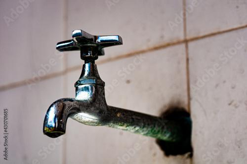 Obraz na płótnie An old tap on a white tile wall.