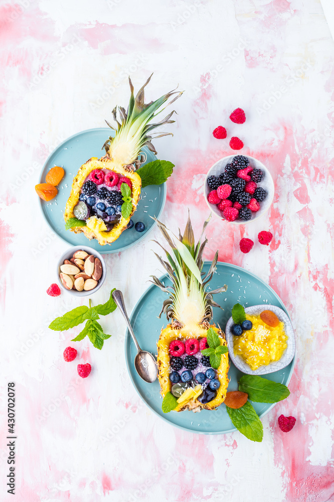 top view of gourmet dessert with halved pineapple and fresh berries on table    