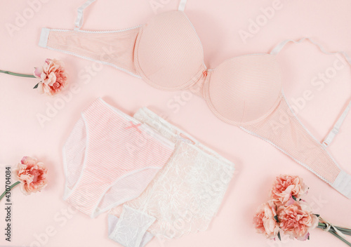 Pink modern lady essentials: bra and cotton panty. Fashionable lingerie, female underwear. Lace gentle panties and bra on pastel pink background. Beauty, fashion, blogger, social media content 