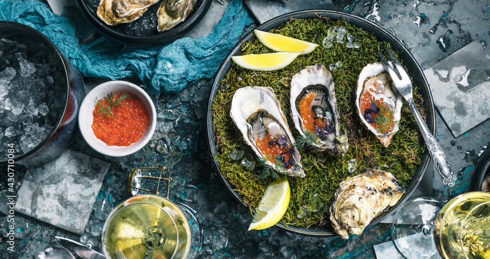 Top view of delicious oysters on ice with lemon and salmon caviar. Top view of delicious oysters on ice with lemon and salmon caviar.