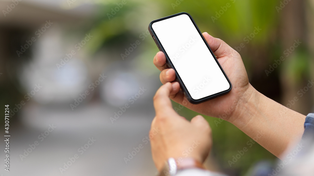 Naklejka premium Male hands using smartphone include clipping path screen in blurred outdoor background