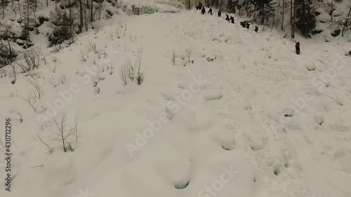 Group of people Climbing in the rough Snow of Lapland, aerial view
drone view of expedition Climbing toward frozen waterfall in Lapland
 photo