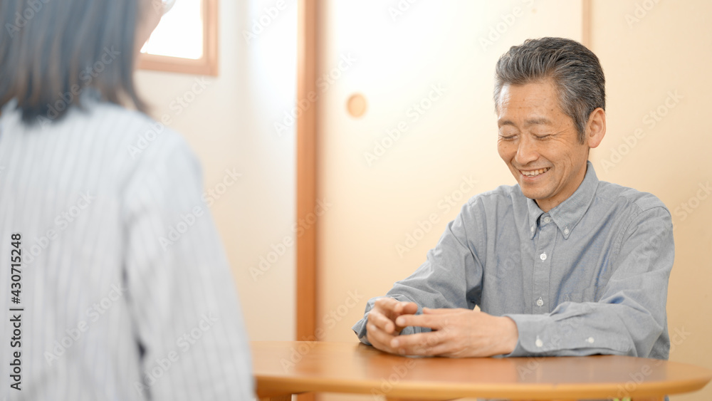 和室で会話をする若い女性とシニア男性 和室で会話をする若い女性とシニア男性
