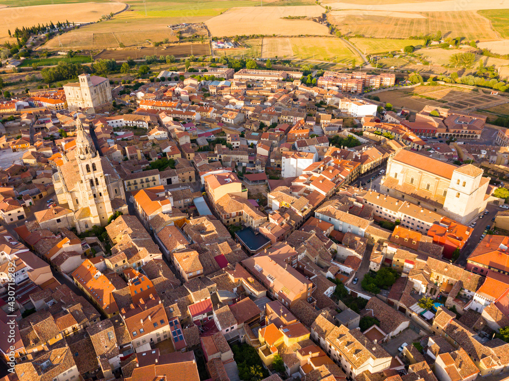 Aerial view of small Spanish city of Medina de Rioseco on background of picturesque landscape with green fields