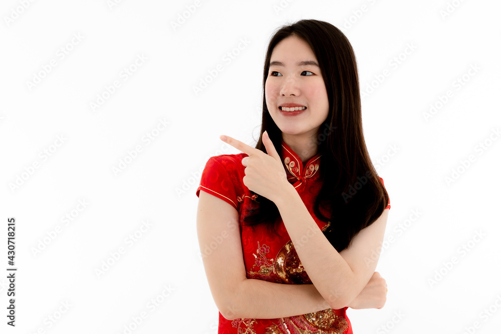 Chinese beautiful woman with long black hairs in red traditional dress is smiling and crossed her arms with her left hand pointing something to the right