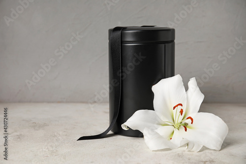 Cuadro en lienzo Mortuary urn and lily flower on light background