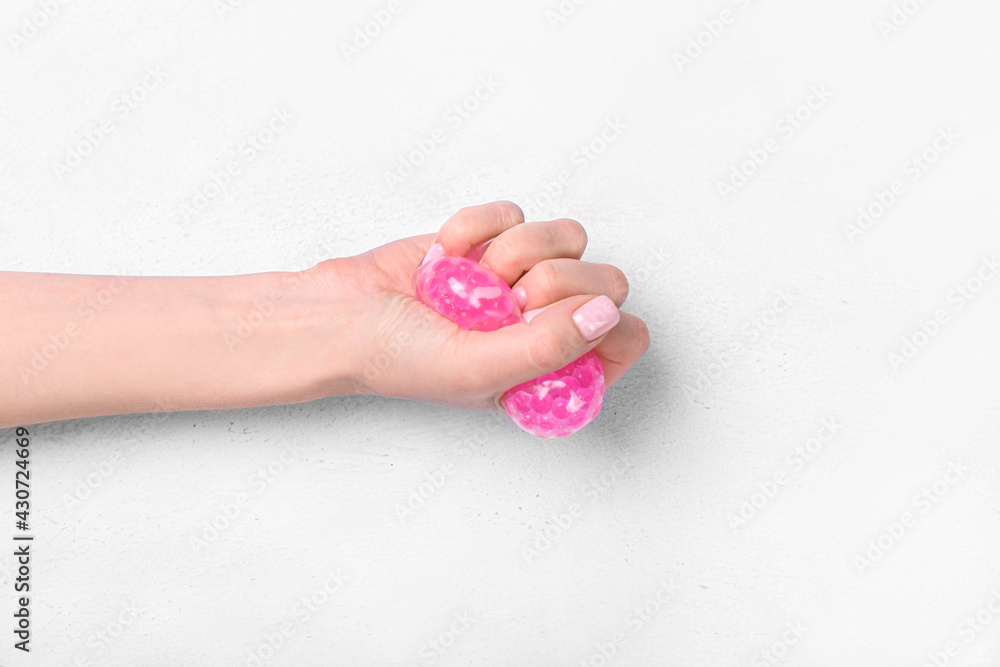 Female hand squeezing stress ball on white background Female hand squeezing stress ball on white background