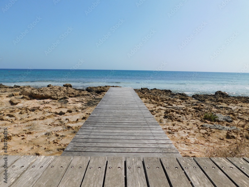 wooden path to the sea against the blue sky. Protaras. Cyprus. April 2021
