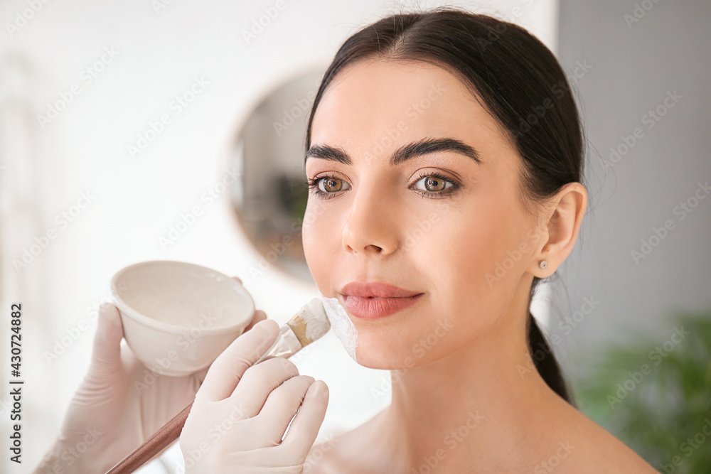 Cosmetologist applying mask on woman's face in beauty salon Cosmetologist applying mask on woman's face in beauty salon