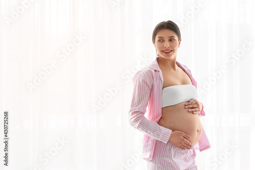 Young pregnant woman near window at home Free Download Young pregnant woman near window at home - GFXLoad