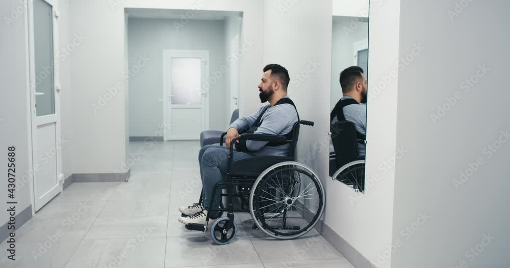 Man with disability waiting in clinic corridor Man with disability waiting in clinic corridor
