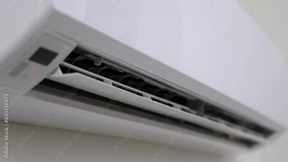 A young man used a remote to turn off the air conditioner. In the living room at home
A young man used a remote to turn off the air conditioner. In the living room at home