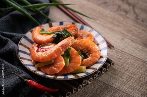 Delicious pan-fried shrimp on dark wooden table background.