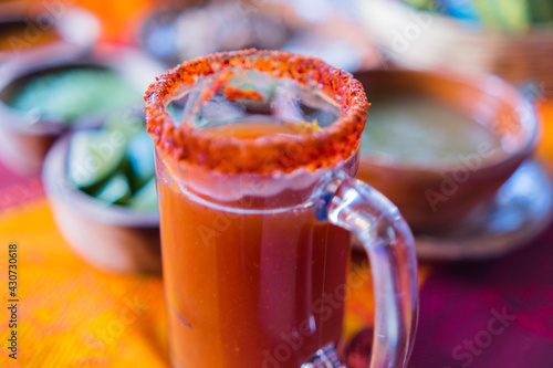 Traditional Mexican michelada in glass mug with blurry background