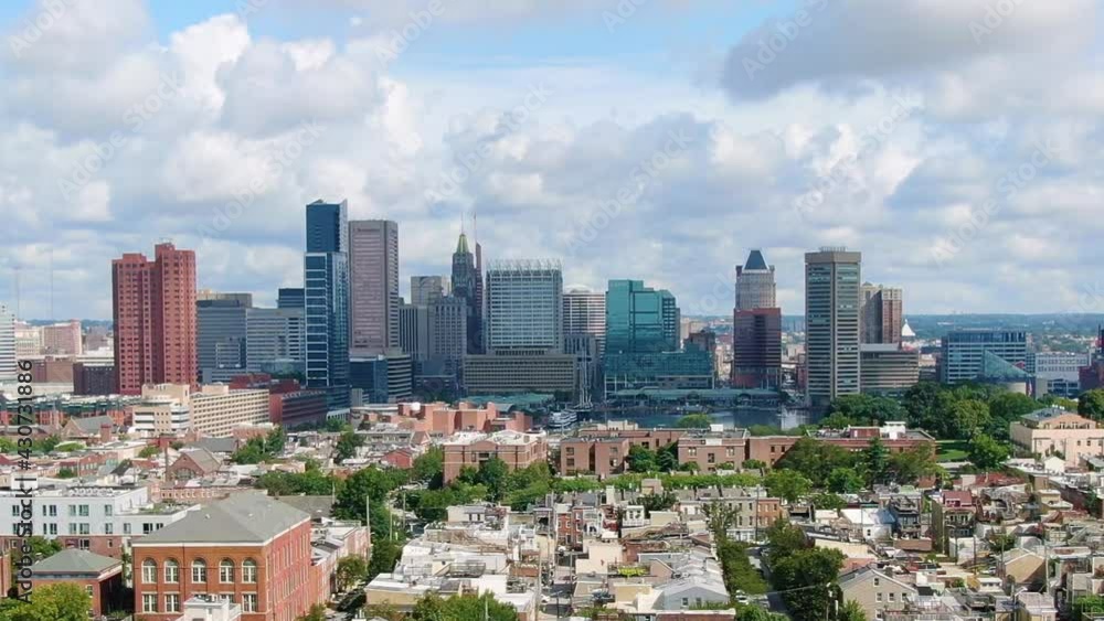 Baltimore skyline. Residential buildings, Inner harbour and skyscrapers in the background on a sunny day over the sky with fluffy clouds Baltimore skyline. Residential buildings, Inner harbour and skyscrapers in the background on a sunny day over the sky with fluffy clouds