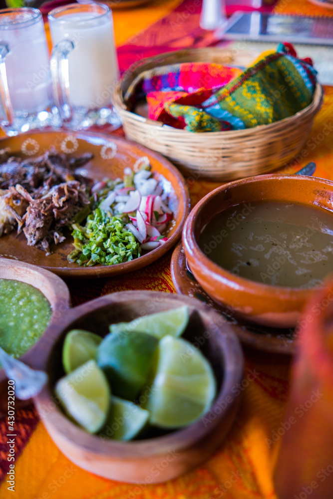Mexican chopped lamb meat, condiments, and two jars of refreshing drink