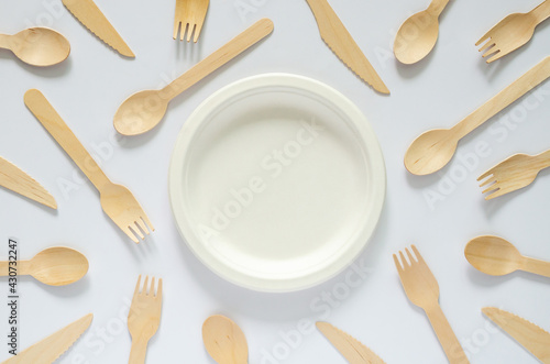 White disposable, compostable dish with fork and spoon on white background for world environment day concept.