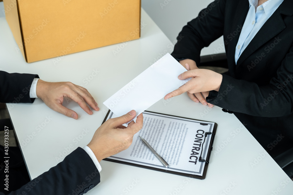 Business woman employee in suit signing on resignation letter and sending to executive while carrying packed Business woman employee in suit signing on resignation letter and sending to executive while carrying packed