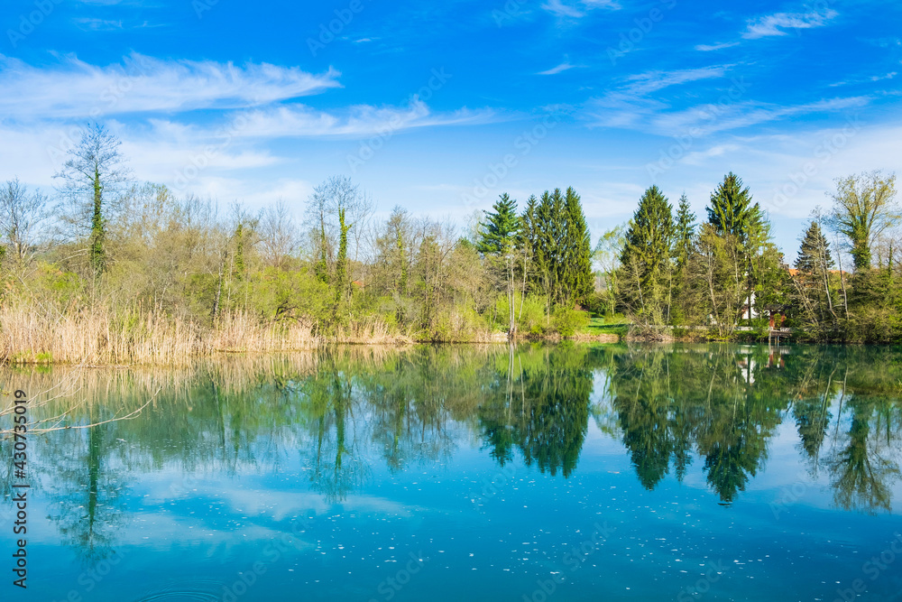 Banks of Mreznica river in Croatia, trees reflection on water, tourist destination Banks of Mreznica river in Croatia, trees reflection on water, tourist destination