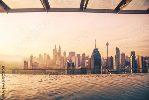 Photography Cityscape of Kuala lumpur city skyline with swimming pool on the roof top of hotel at sunrise in Malaysia