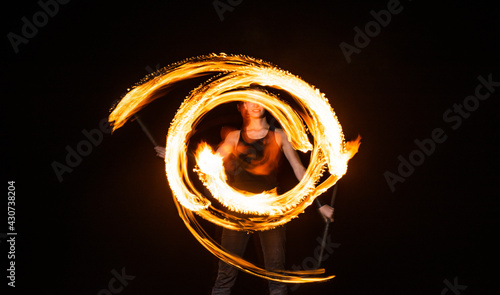 Foto female fire dancer twirl burning baton creating sparkling trails in motion dark