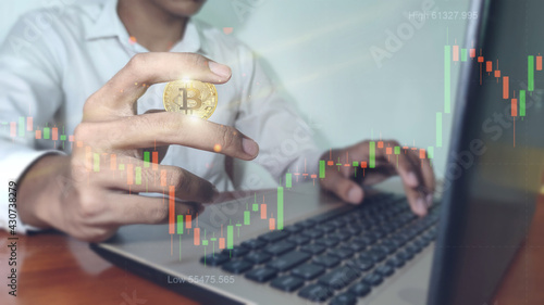 Bitcoin gold coin and defocused chart background. Business man with bitcoins. Virtual cryptocurrency concept.