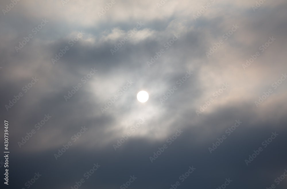 The sun shines behind the clouds during The sun shines behind the clouds during