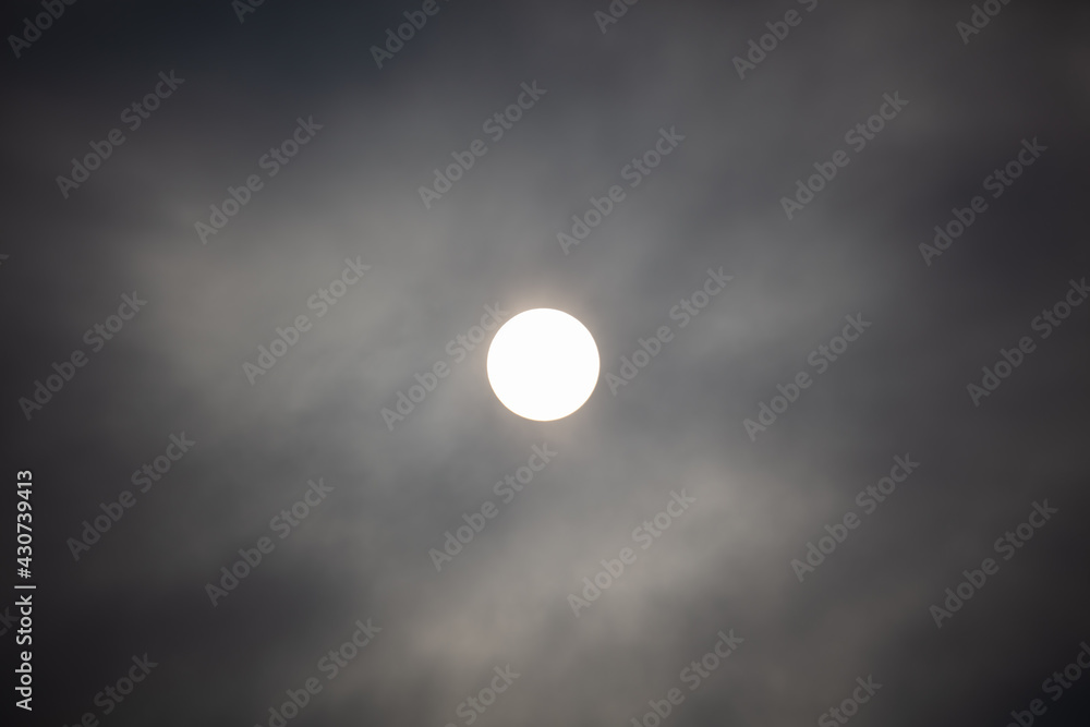 The sun shines behind the clouds during The sun shines behind the clouds during