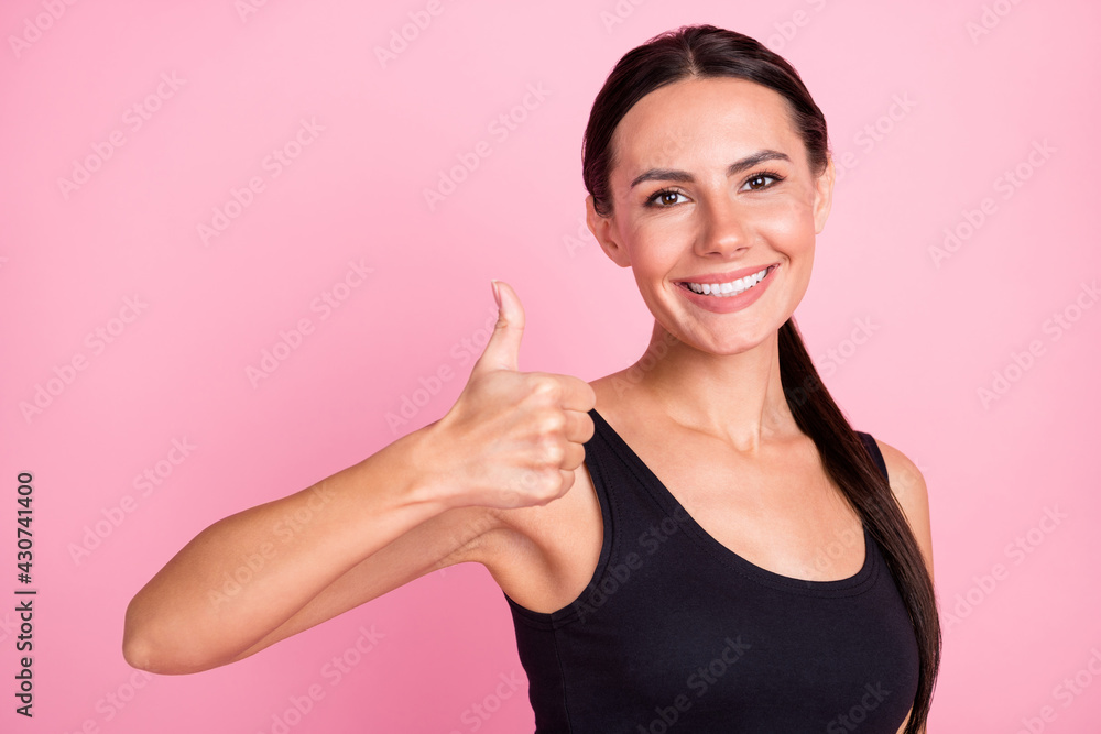 Photo of cheerful happy nice young woman hold hand show thumb-up smile isolated on pastel pink color background Photo of cheerful happy nice young woman hold hand show thumb-up smile isolated on pastel pink color background