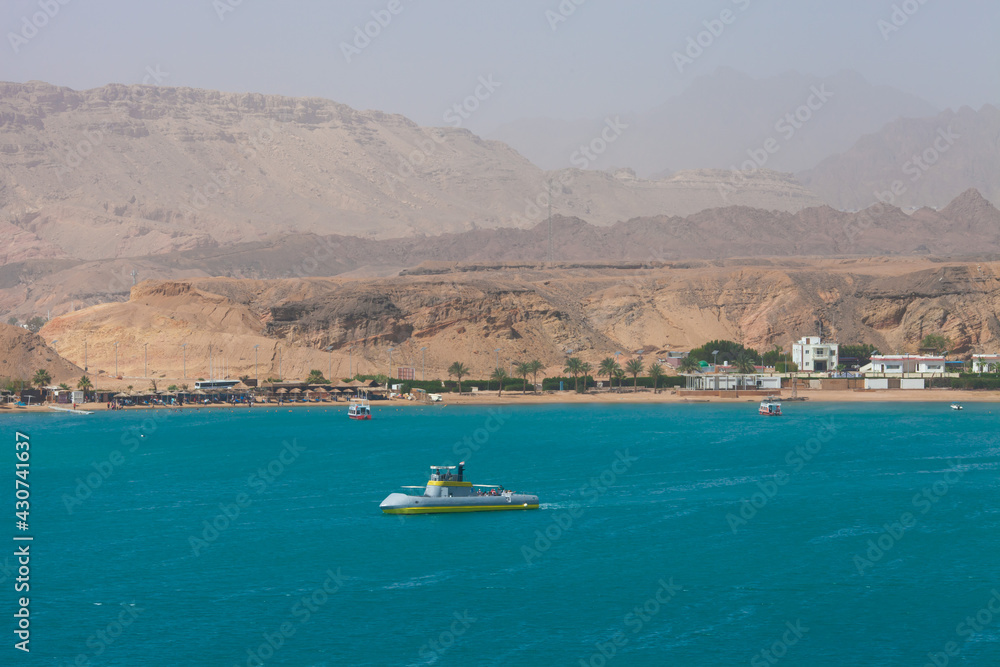 Excursion submarine, Red sea and Sinai mountains on a background. Boat trips and sightseeing in Egypt, Sharm el-Sheikh. Travel and tourism concept.