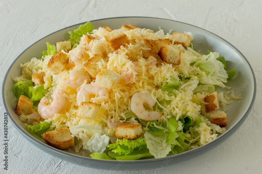 Homemade Shrimp Caesar Salad with parmesa, sauce and Croutons on a white background Homemade Shrimp Caesar Salad with parmesa, sauce and Croutons on a white background