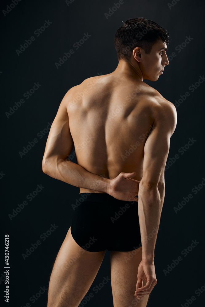 attractive athletic man in black shorts back view