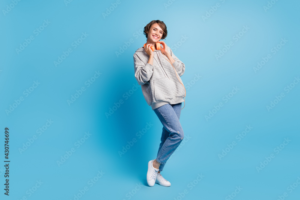 Ful length photo portrait of cute girl with headphones isolated on pastel blue colored background Ful length photo portrait of cute girl with headphones isolated on pastel blue colored background