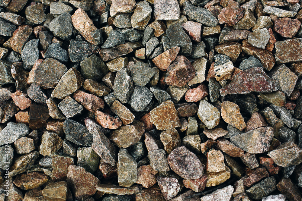 Many brown and grey stones rocks with variegated texture, rough brutal background Many brown and grey stones rocks with variegated texture, rough brutal background
