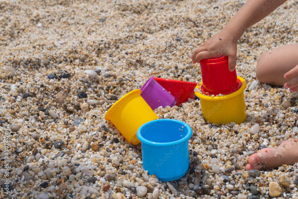 Colorful toys and children hand, playing at the sand, happy childhood, copy space. Colorful toys and children hand, playing at the sand, happy childhood, copy space.