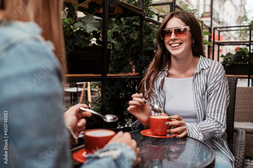 Two Young Women Drinking Coffee in Cafe Outdoors, Lunch Time Concept, Brunette Girl in Focus