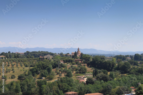 Un village italien en Toscane sur le sommet d une colline par une belle journée estivale, le ciel est bleu, les montagnes se distinguent au loin.
