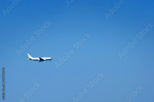 A white plane against a clear blue sky