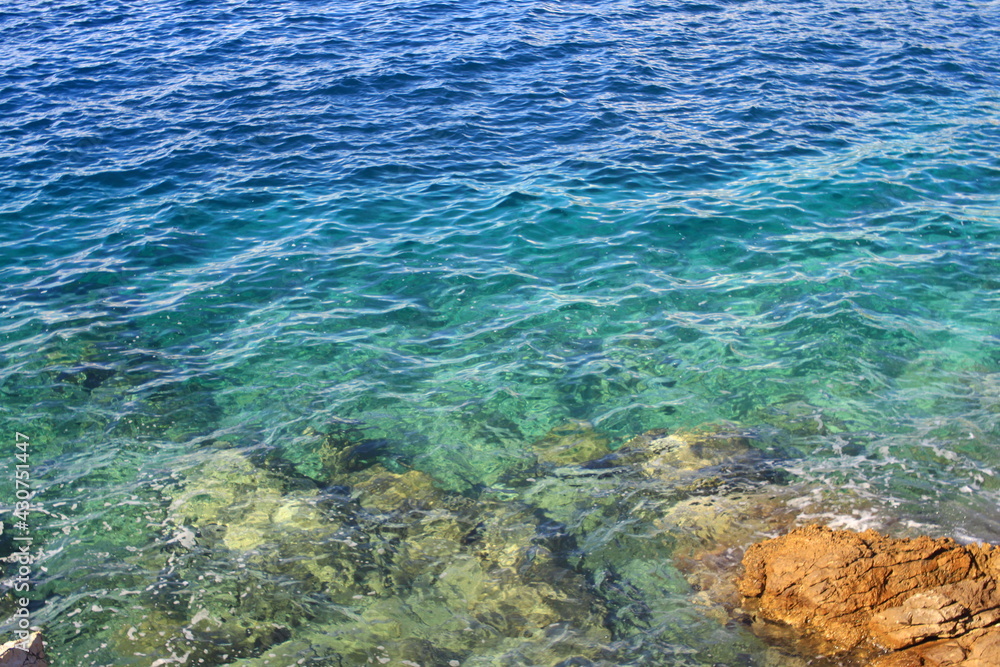 La mer bleu émeraude avec de petites vagues et des rochers blancs et jaunes dans l eau