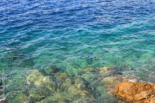 La mer bleu émeraude avec de petites vagues et des rochers blancs et jaunes dans l eau