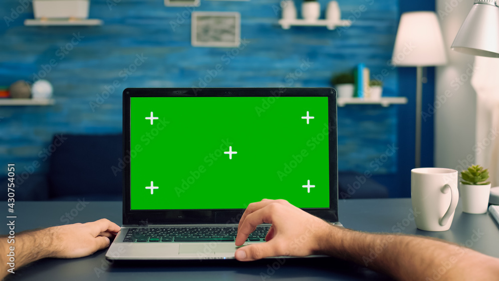 Point of view of man hands typing on laptop computer with mock up green screen chroma key display for e commerce courses. Freelancer using isolated device standing on desk table in home office studio Point of view of man hands typing on laptop computer with mock up green screen chroma key display for e commerce courses. Freelancer using isolated device standing on desk table in home office studio